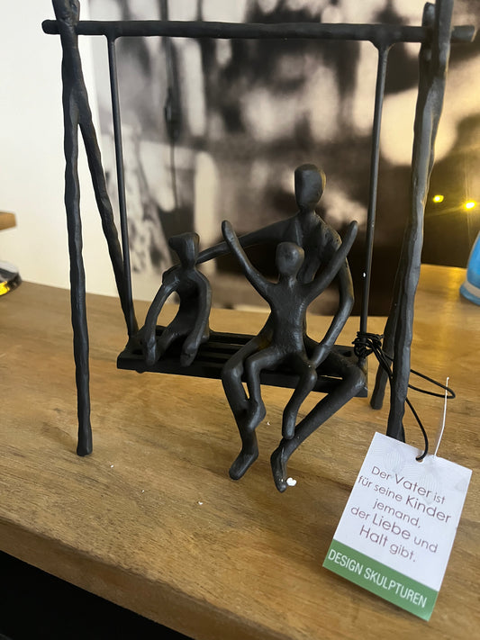 Skulptur, Vater mit Kindern auf Schaukel