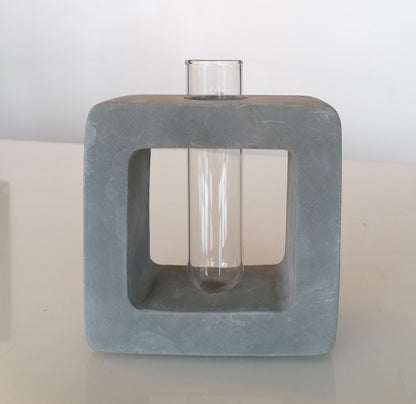 Betoncubus mit Vase für eine Blume